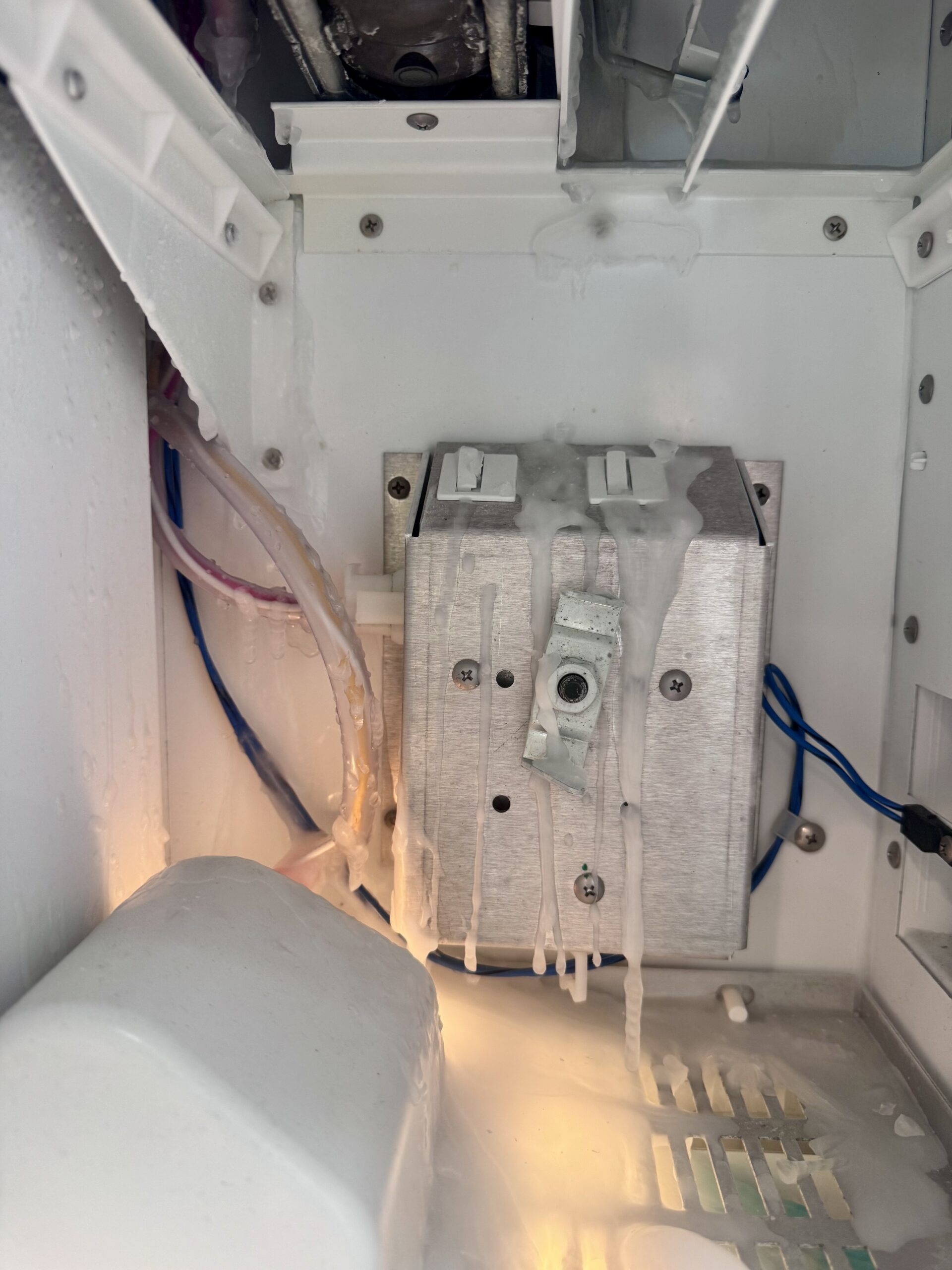 Frozen water spilled and iced over on Sub-Zero auger motor area