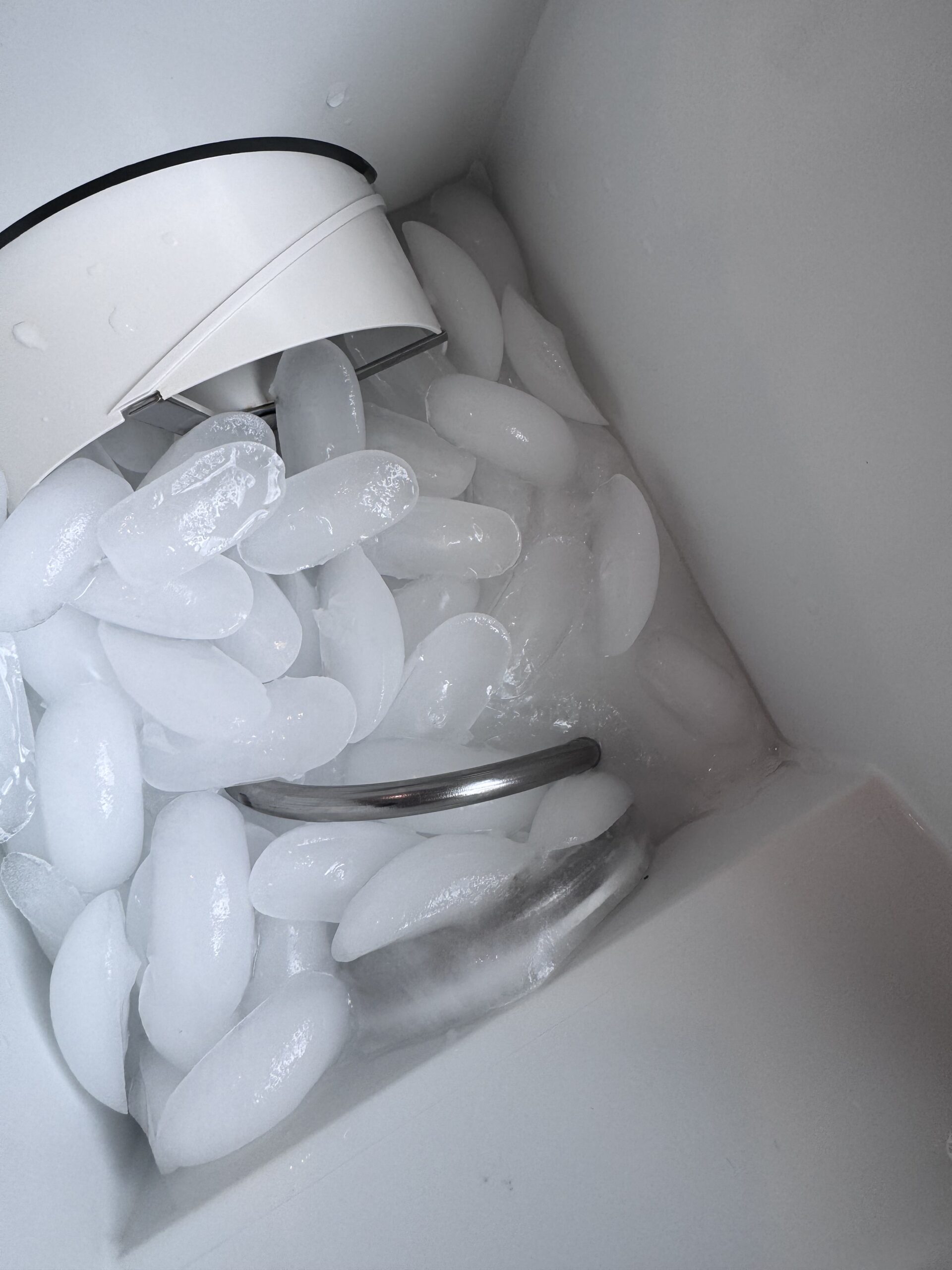 Frozen water and finished ice stuck together inside Sub-Zero ice bin